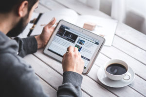 Homme qui consulte un site internet sur une tablette