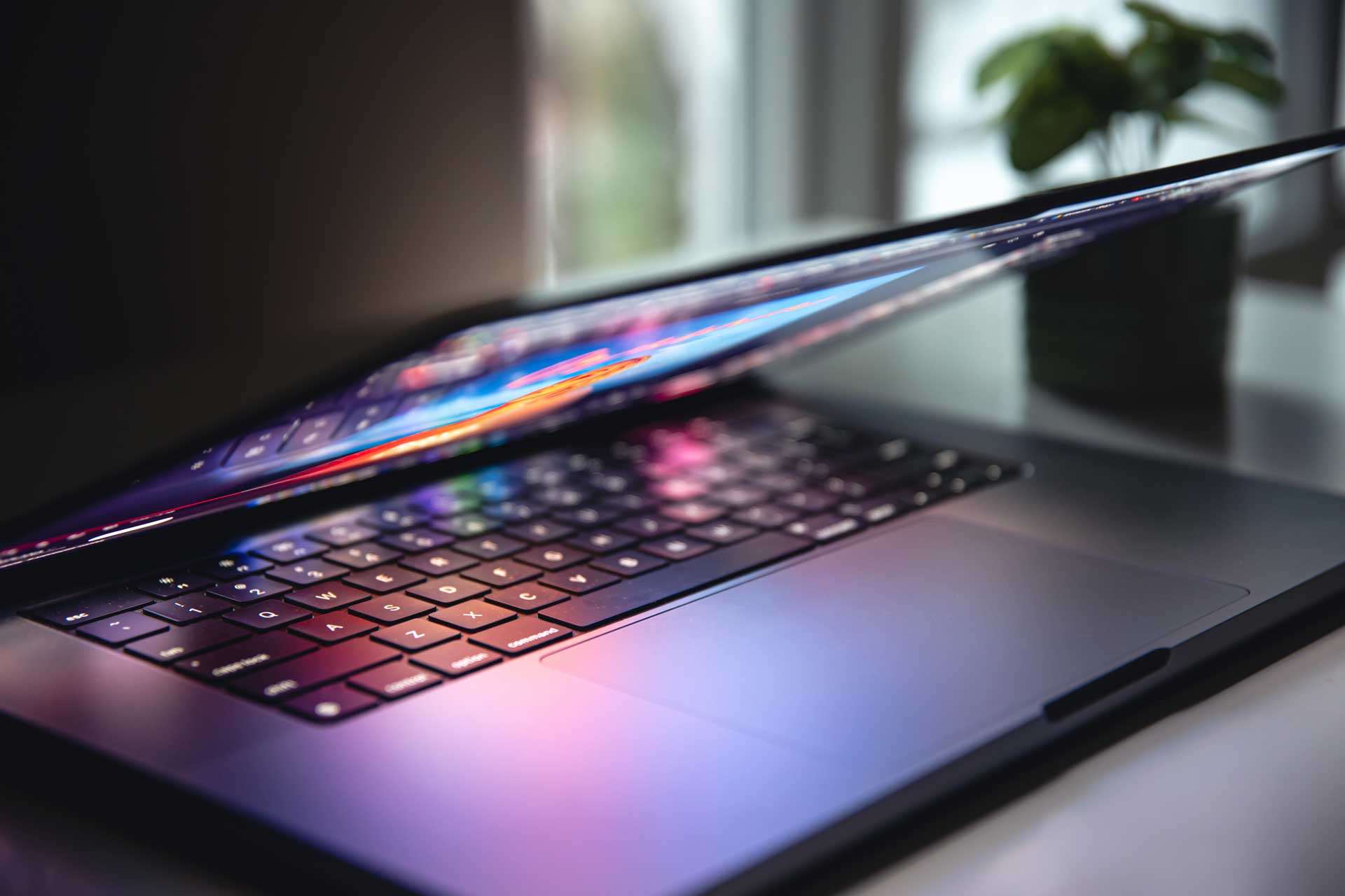 Ordinateur portable allumé, avec clavier rétroéclairé, dans la pénombre